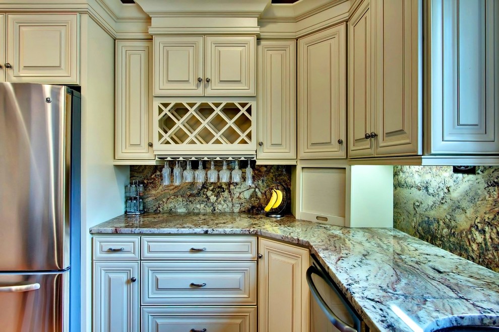 Inspiration for a traditional kitchen in Cincinnati with raised-panel cabinets, beige cabinets, granite benchtops, stone slab splashback and stainless steel appliances.