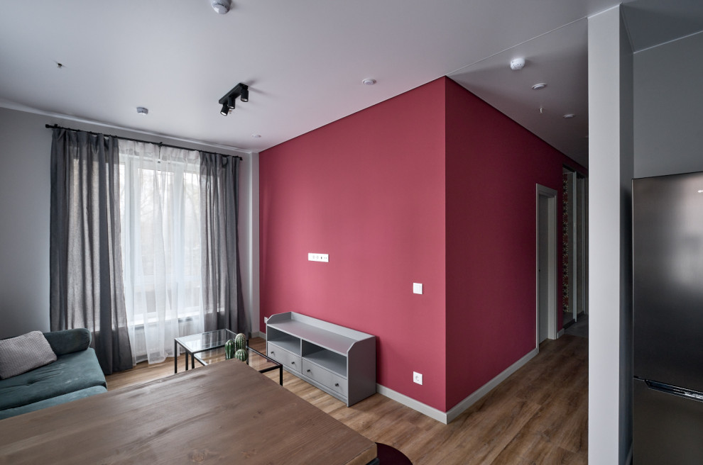 Источник вдохновения для домашнего уюта: маленькая открытая гостиная комната в современном стиле с домашним баром, розовыми стенами, полом из винила, телевизором на стене, коричневым полом и тюлем на окнах для на участке и в саду