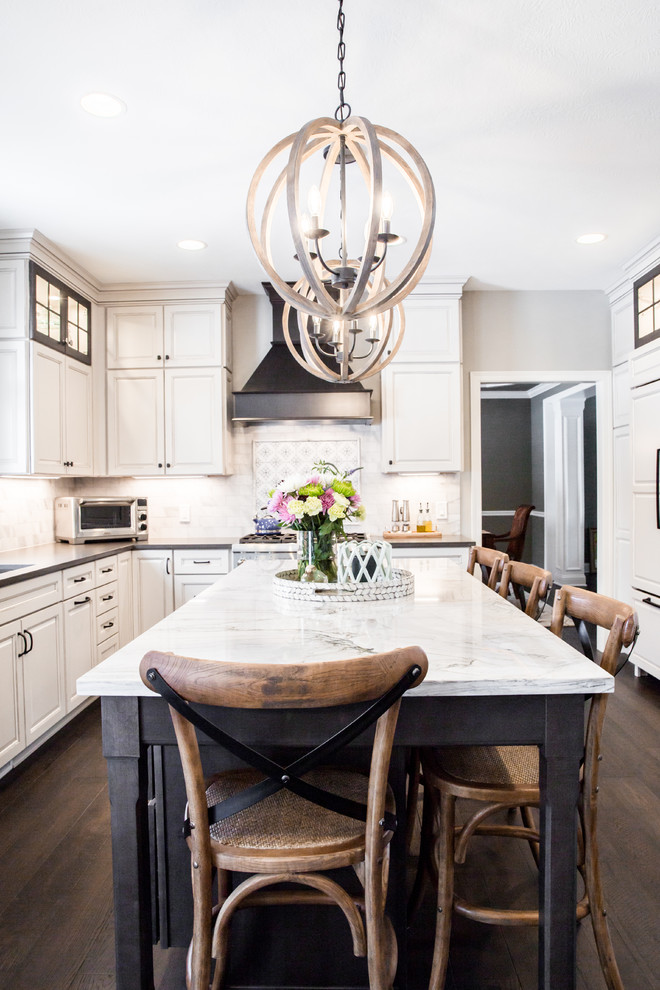 Large transitional eat-in kitchen in Cleveland with an undermount sink, raised-panel cabinets, white cabinets, quartzite benchtops, grey splashback, marble splashback, panelled appliances, dark hardwood floors, with island, black floor and grey benchtop.