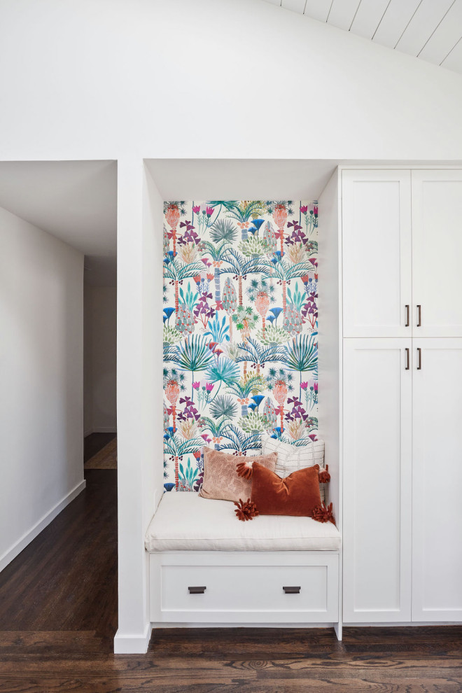 Small 1950s medium tone wood floor, vaulted ceiling and wallpaper entryway photo in San Francisco with brown walls and a white front door