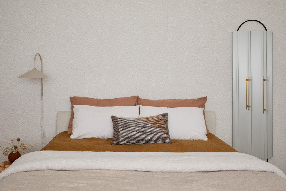 Cette photo montre une petite chambre parentale scandinave avec un mur beige, parquet clair, un sol marron et du papier peint.
