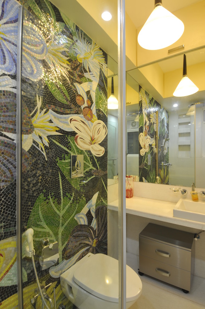 This is an example of a contemporary bathroom in Mumbai with mosaic tile and a wall-mount toilet.