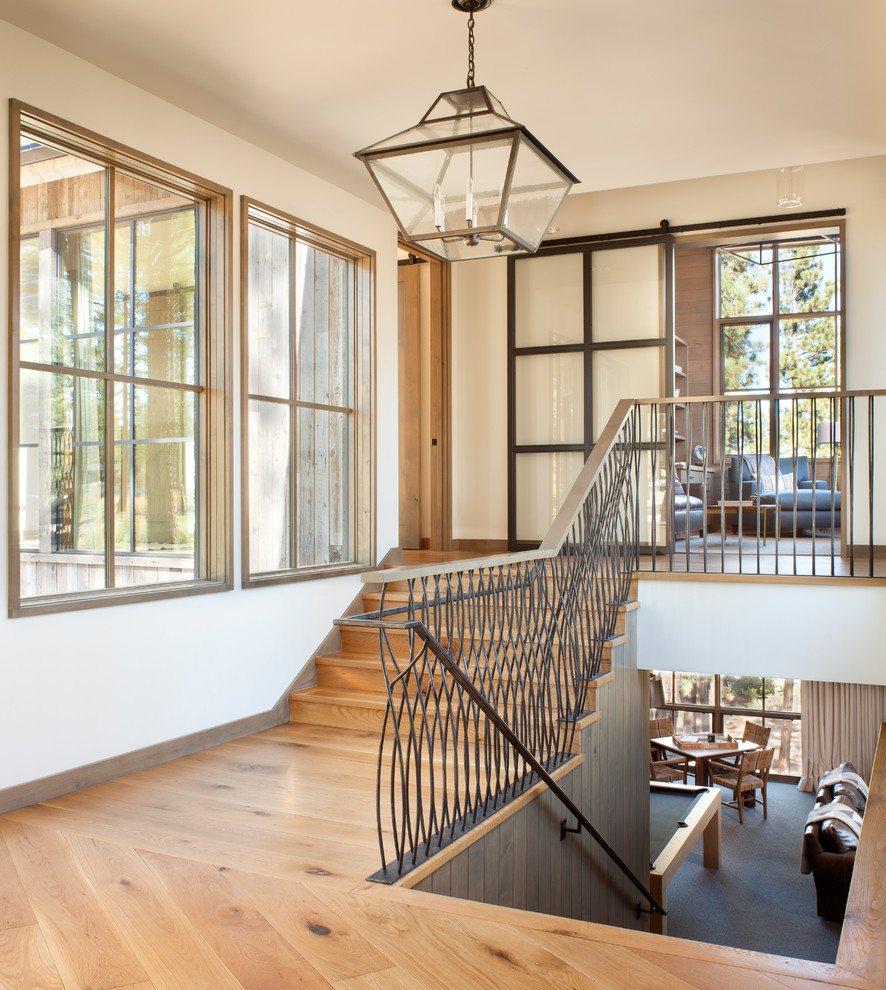 This is an example of a large country wood u-shaped staircase in Sacramento with wood risers and metal railing.