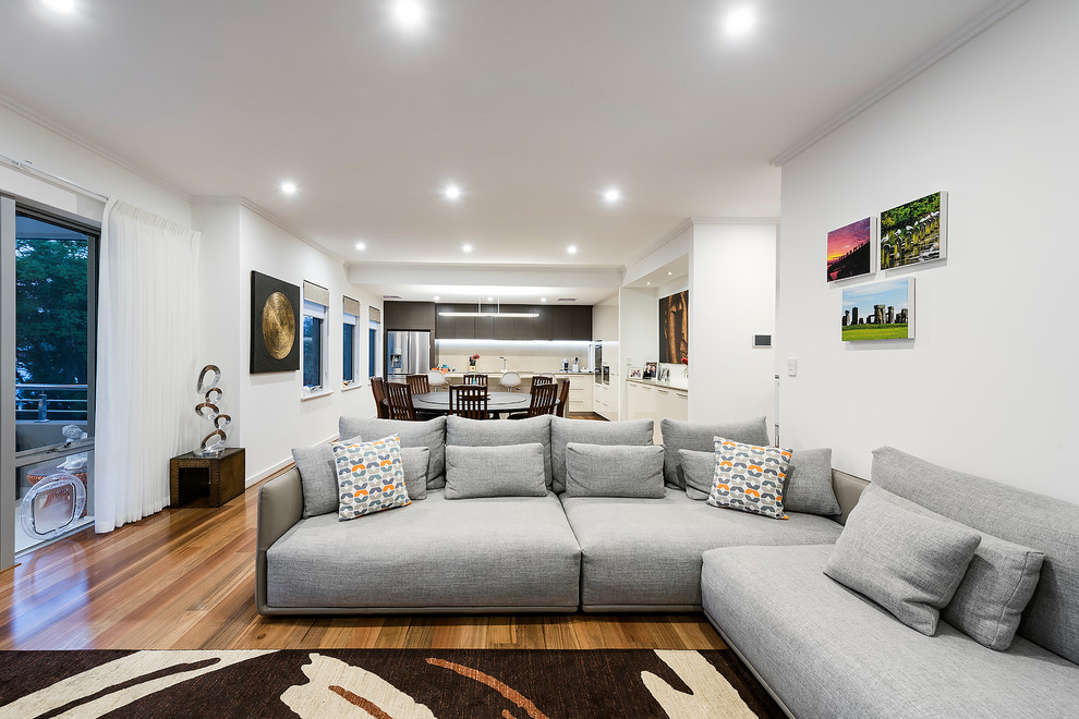 Design ideas for a contemporary open concept living room in Perth with white walls and brown floor.