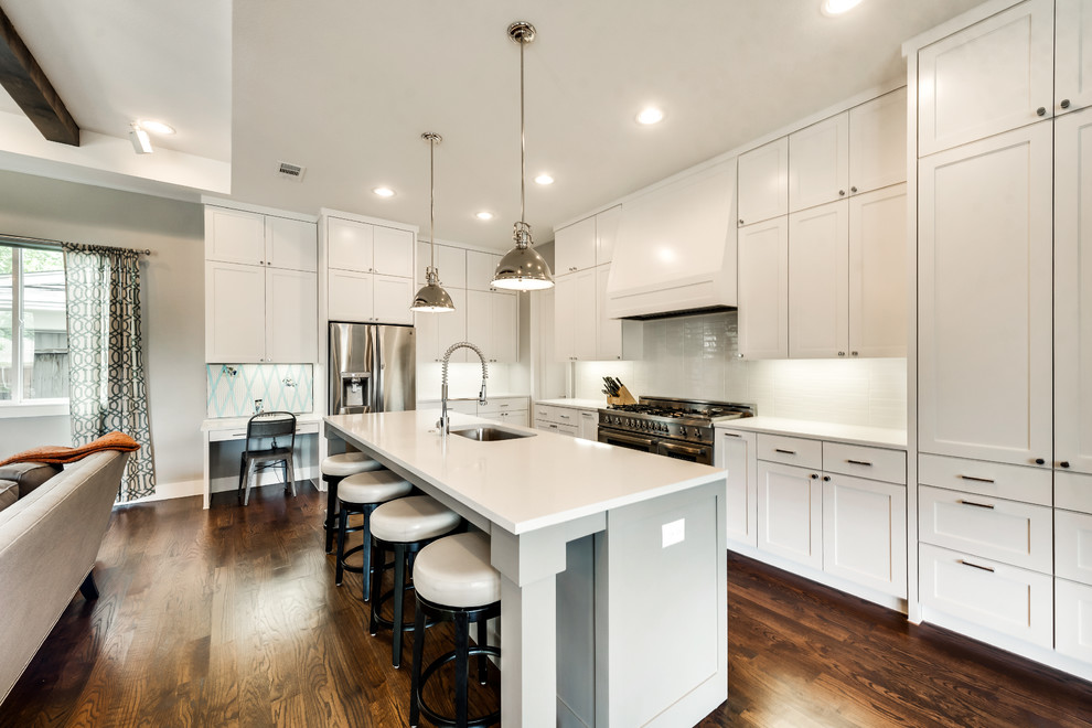 Photo of a country l-shaped eat-in kitchen in Dallas with an undermount sink, shaker cabinets, grey cabinets, quartzite benchtops, white splashback, subway tile splashback, stainless steel appliances, medium hardwood floors, with island and brown floor.