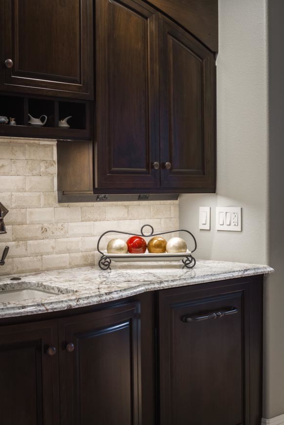 Eat-in kitchen - transitional eat-in kitchen idea with an undermount sink, raised-panel cabinets, dark wood cabinets, stainless steel appliances and an island