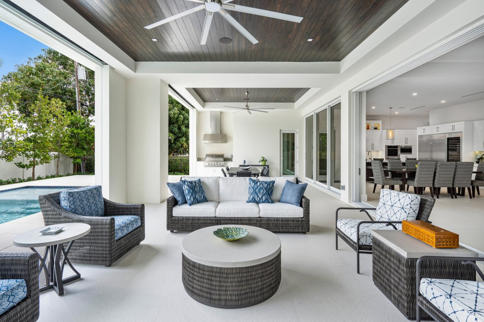 Inspiration for a large contemporary back patio in Miami with an outdoor kitchen, tiled flooring and a roof extension.