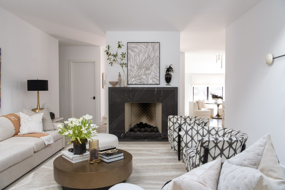 Cette image montre un petit salon design ouvert avec un manteau de cheminée en pierre, un sol gris, une salle de réception, un mur blanc, sol en béton ciré et une cheminée standard.