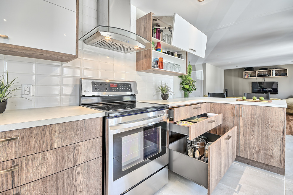 Design ideas for a small contemporary l-shaped eat-in kitchen in Montreal with an undermount sink, flat-panel cabinets, light wood cabinets, laminate benchtops, white splashback, subway tile splashback, white appliances, ceramic floors and a peninsula.
