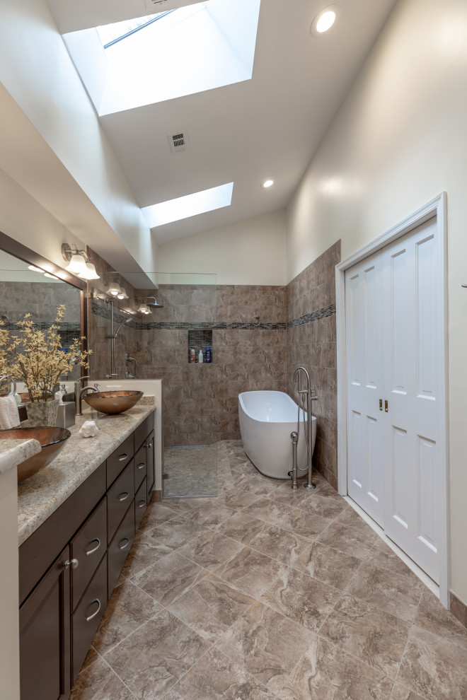 Small contemporary ensuite bathroom in DC Metro with brown cabinets, a freestanding bath, a walk-in shower, a one-piece toilet, beige walls, a vessel sink, grey floors, brown worktops, double sinks and a built in vanity unit.