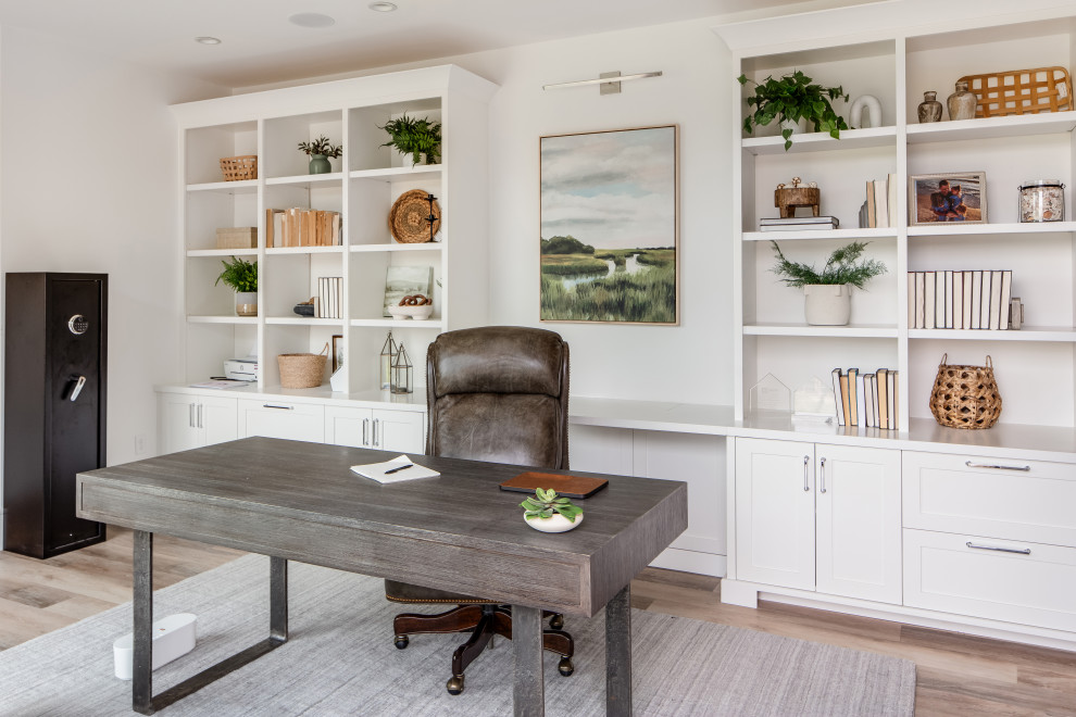 Exemple d'un grand bureau nature avec une bibliothèque ou un coin lecture, un mur blanc, parquet clair, un bureau intégré et un sol marron.