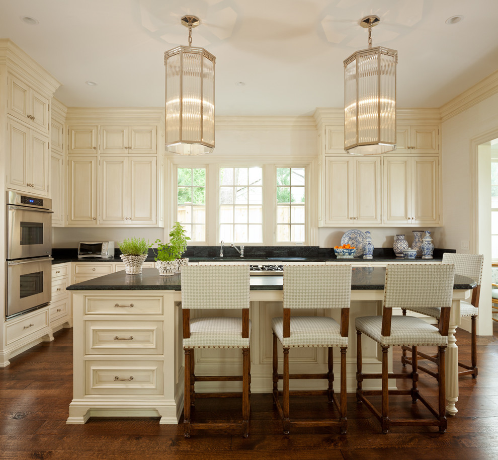 Traditional kitchen in DC Metro with raised-panel cabinets, beige cabinets and stainless steel appliances.