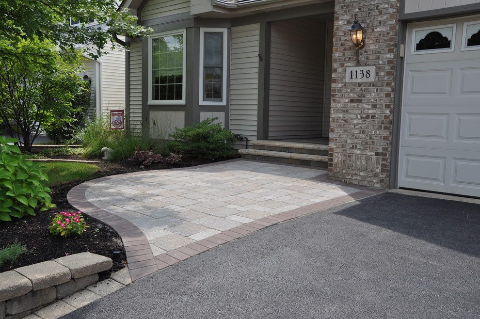 This is an example of a small traditional front yard patio in Chicago with brick pavers and a roof extension.