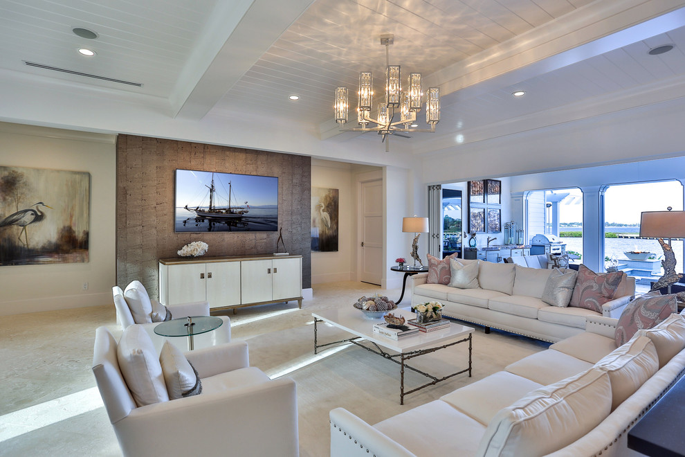 Design ideas for a mid-sized transitional open concept family room in Miami with white walls, travertine floors, a wall-mounted tv and no fireplace.