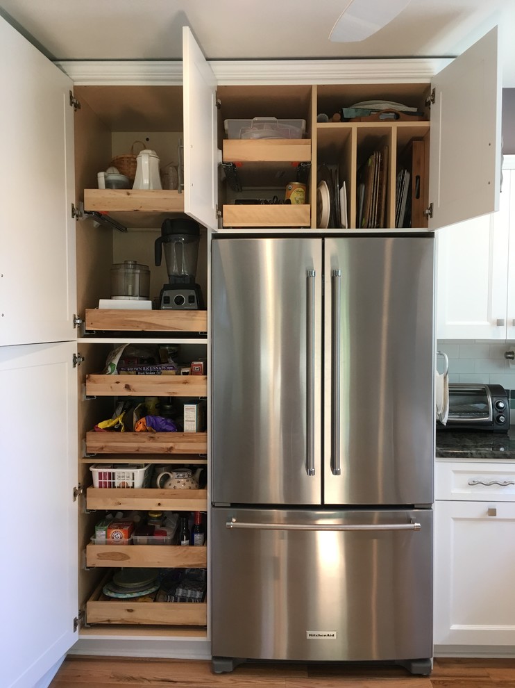 Inspiration for a mid-sized transitional l-shaped light wood floor enclosed kitchen remodel with an undermount sink, flat-panel cabinets, white cabinets, granite countertops, white backsplash, subway tile backsplash, stainless steel appliances and no island