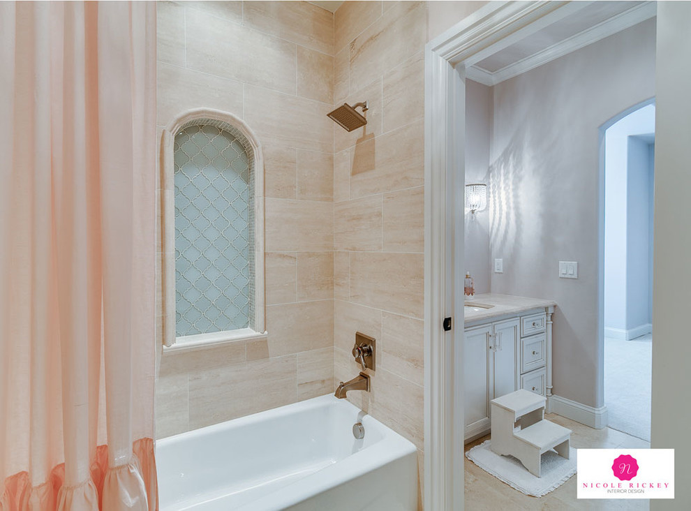 Mid-sized transitional kids bathroom in Oklahoma City with flat-panel cabinets, white cabinets, a drop-in tub, a shower/bathtub combo, a two-piece toilet, beige tile, travertine, pink walls, an undermount sink, marble benchtops, a shower curtain, travertine floors and beige floor.