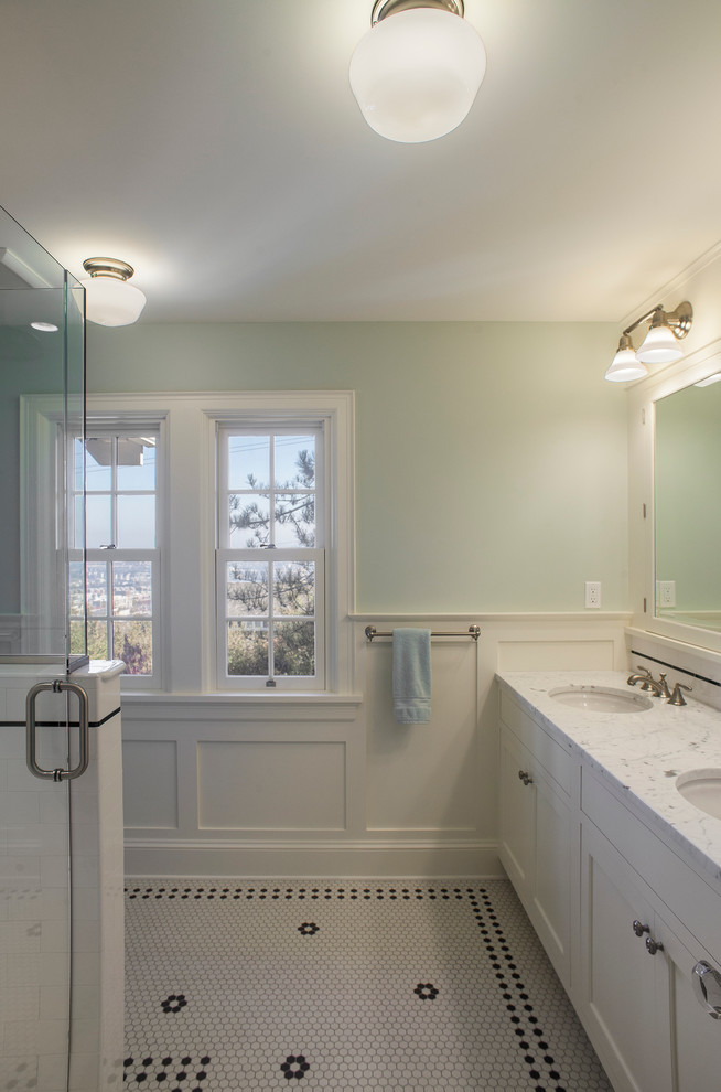 Photo of a mid-sized arts and crafts master bathroom in Portland with beaded inset cabinets, white cabinets, a corner shower, white tile, subway tile, blue walls, mosaic tile floors, an undermount sink and marble benchtops.