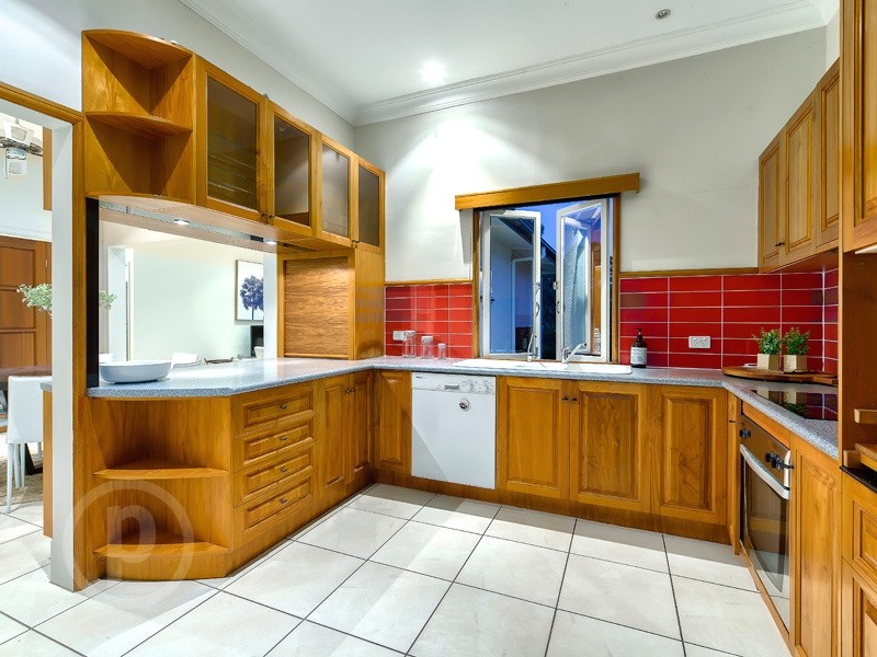 Inspiration for a mid-sized transitional u-shaped separate kitchen in Brisbane with a drop-in sink, beaded inset cabinets, medium wood cabinets, laminate benchtops, red splashback, ceramic splashback, white appliances and ceramic floors.