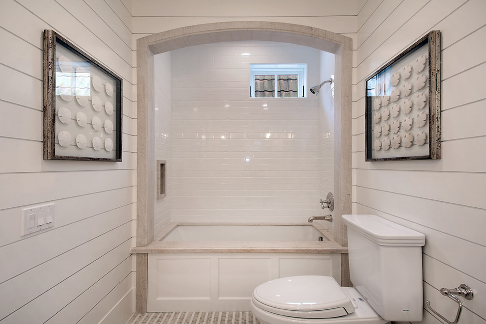 Design ideas for a beach style bathroom in Orange County with an undermount tub, a shower/bathtub combo, a two-piece toilet, white tile and subway tile.