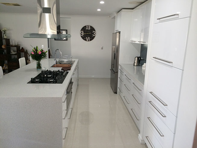 Contemporary single-wall eat-in kitchen in Perth with a double-bowl sink, flat-panel cabinets, white cabinets, granite benchtops, black splashback, glass sheet splashback, stainless steel appliances, porcelain floors and with island.