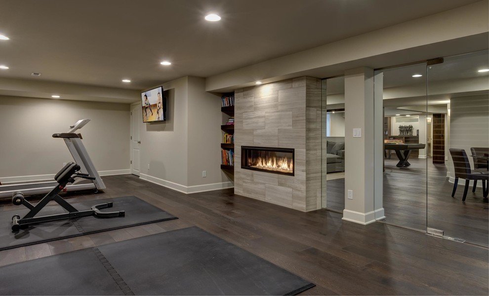 Inspiration for an expansive contemporary look-out basement in Denver with grey walls, dark hardwood floors, a ribbon fireplace, a tile fireplace surround and brown floor.
