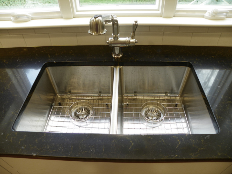 Inspiration for a mid-sized transitional u-shaped light wood floor eat-in kitchen remodel in Boston with an undermount sink, beaded inset cabinets, white cabinets, quartz countertops, white backsplash, subway tile backsplash, stainless steel appliances and no island
