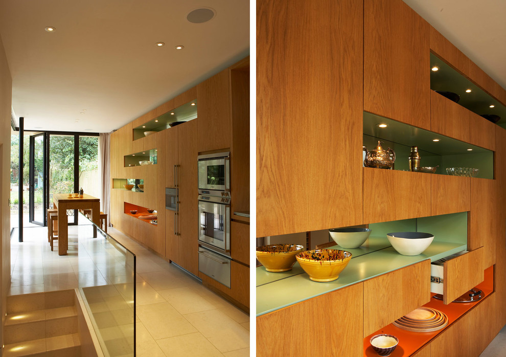 Photo of a mid-sized modern galley eat-in kitchen in London with light wood cabinets and no island.