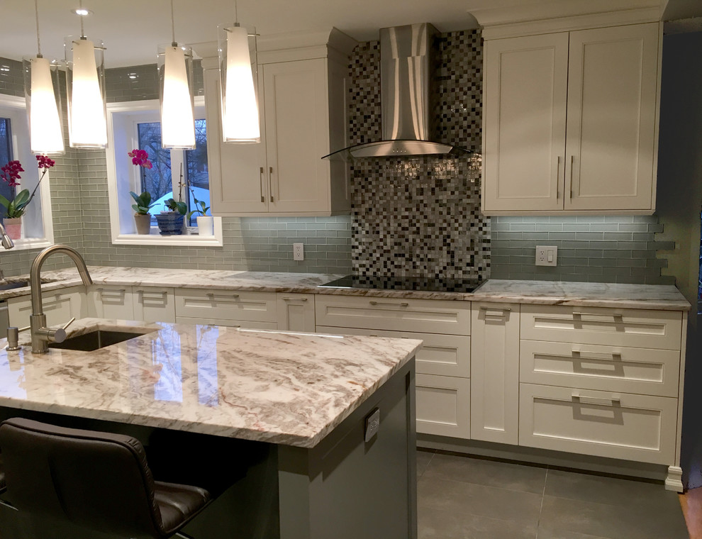 This is an example of a large traditional l-shaped eat-in kitchen in Montreal with an undermount sink, shaker cabinets, white cabinets, quartzite benchtops, grey splashback, glass tile splashback, stainless steel appliances, ceramic floors and with island.