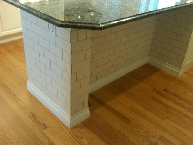 Inspiration for a mid-sized transitional galley concrete floor open concept kitchen remodel in St Louis with a farmhouse sink, shaker cabinets, medium tone wood cabinets, granite countertops, white backsplash, ceramic backsplash, stainless steel appliances and an island