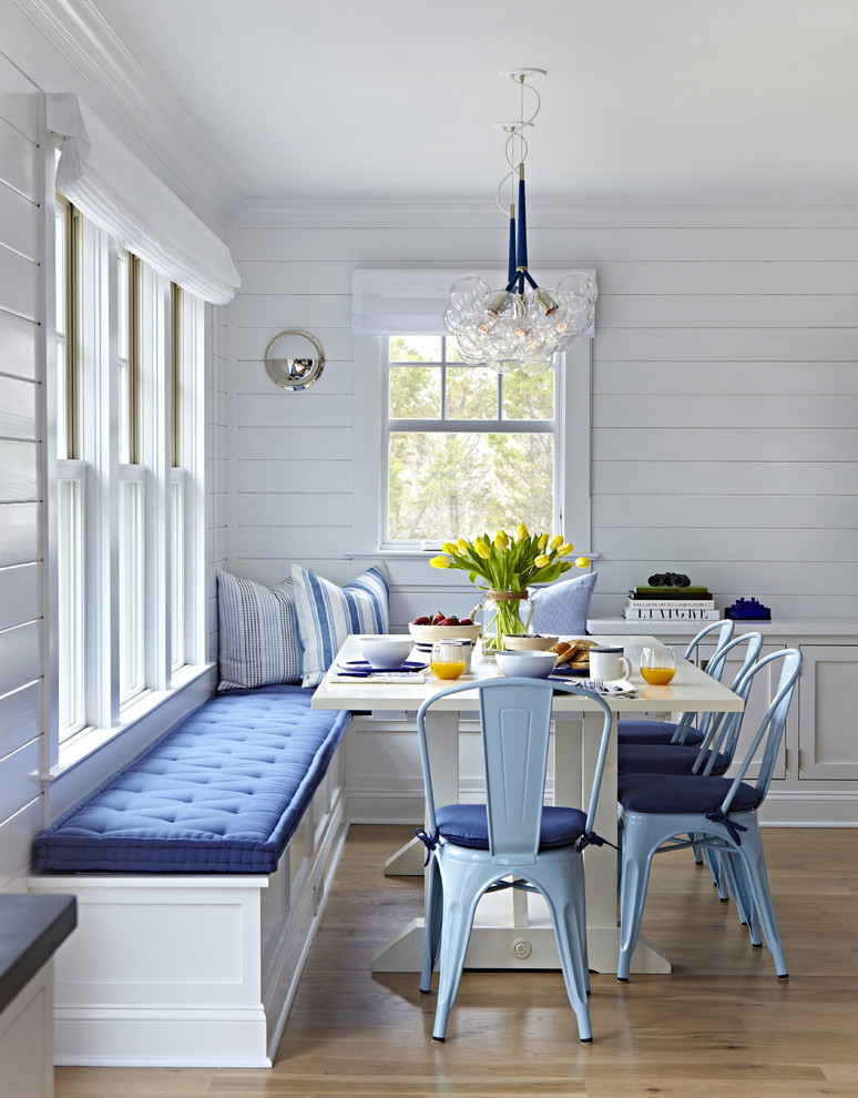 Photo of a mid-sized beach style dining room in New York with white walls, light hardwood floors and no fireplace.