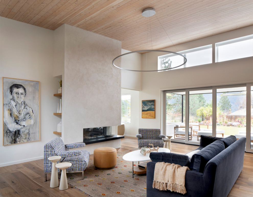 Immagine di un soggiorno minimalista aperto con pavimento in legno massello medio e camino ad angolo