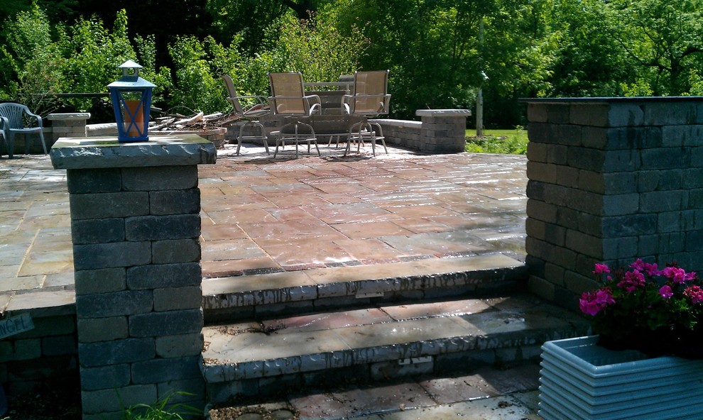 This is an example of a large traditional backyard patio in Chicago with concrete slab and no cover.