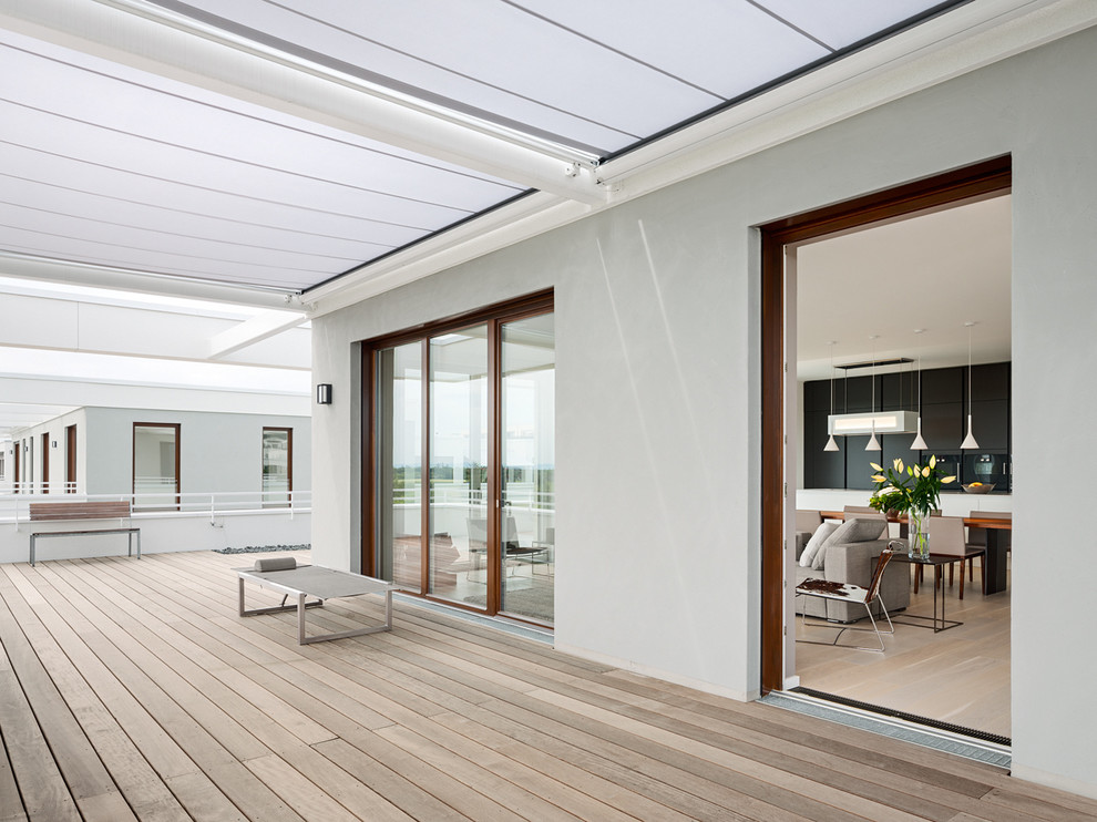 This is an example of an expansive contemporary balcony in Berlin with an awning.