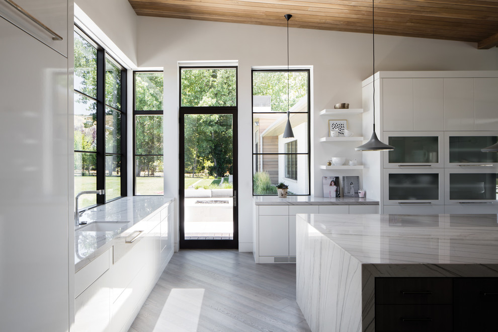 Mid-sized contemporary l-shaped kitchen in Other with an undermount sink, flat-panel cabinets, white cabinets, quartzite benchtops, panelled appliances, with island, grey floor and vinyl floors.