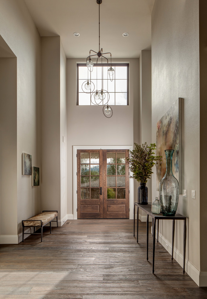 Photo of a large country foyer in Portland with multi-coloured walls, dark hardwood floors, a double front door and a medium wood front door.