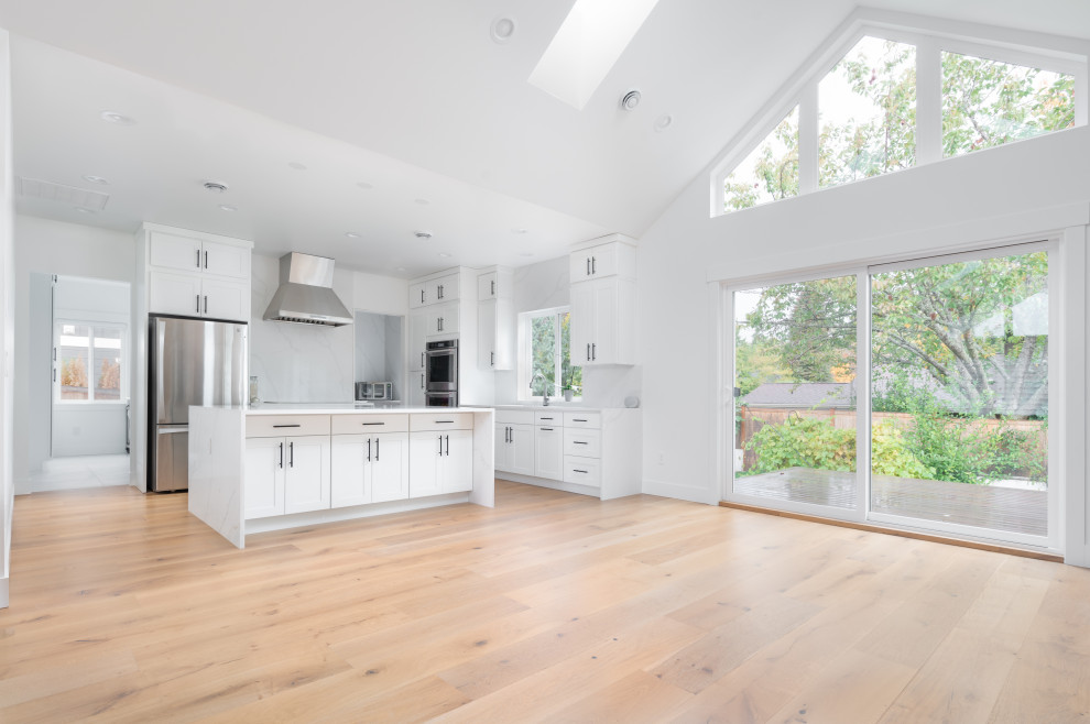 Expansive scandinavian open concept living room in Seattle with white walls, light hardwood floors and beige floor.