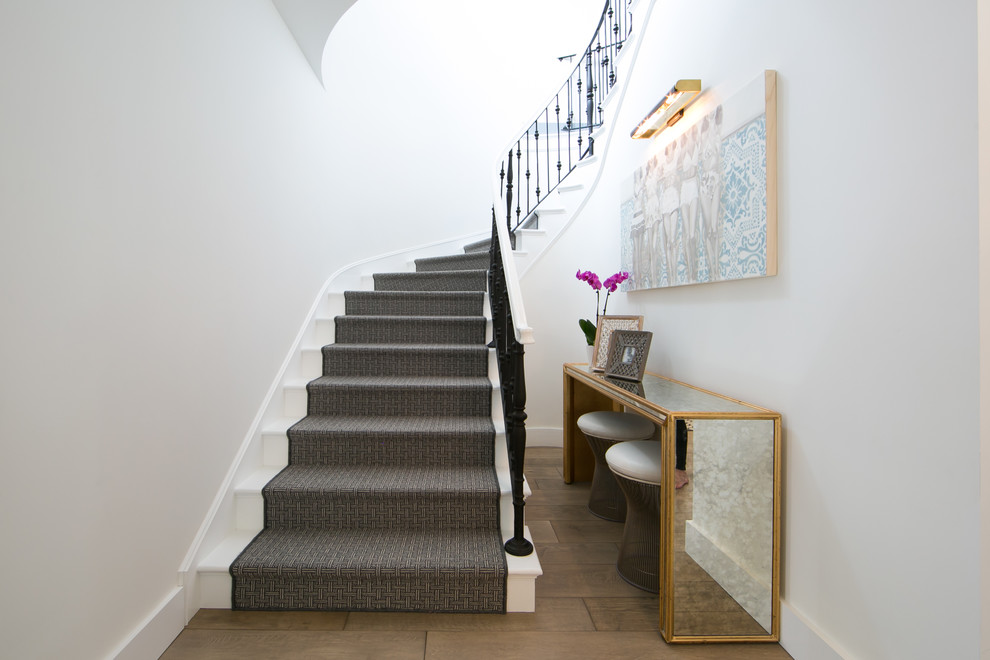 Inspiration for a transitional painted curved staircase remodel in Orange County with painted risers
