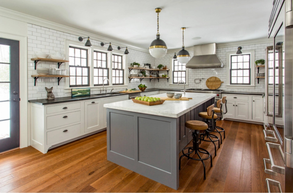 Landhaus Küche mit Küchengeräten aus Edelstahl, braunem Holzboden und Kücheninsel in Boston