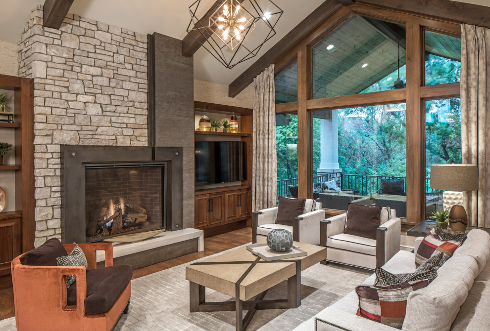 Inspiration for a transitional living room in Omaha with beige walls, medium hardwood floors, a standard fireplace, a metal fireplace surround, a built-in media wall and brown floor.