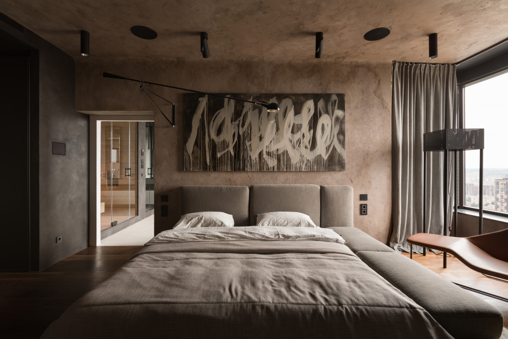 This is an example of a medium sized industrial master bedroom in Los Angeles with brown walls, medium hardwood flooring, brown floors and feature lighting.