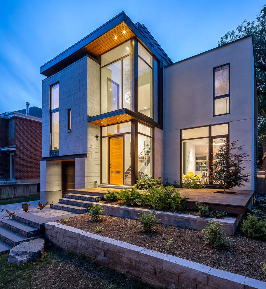 This is an example of a contemporary two-storey grey exterior in Ottawa with stone veneer.
