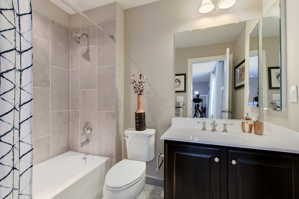 Mid-sized traditional 3/4 bathroom in DC Metro with raised-panel cabinets, dark wood cabinets, an alcove tub, a shower/bathtub combo, a two-piece toilet, beige tile, porcelain tile, beige walls and an integrated sink.