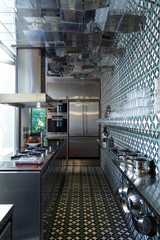 Photo of an eclectic separate kitchen in London with flat-panel cabinets, multi-coloured splashback and with island.