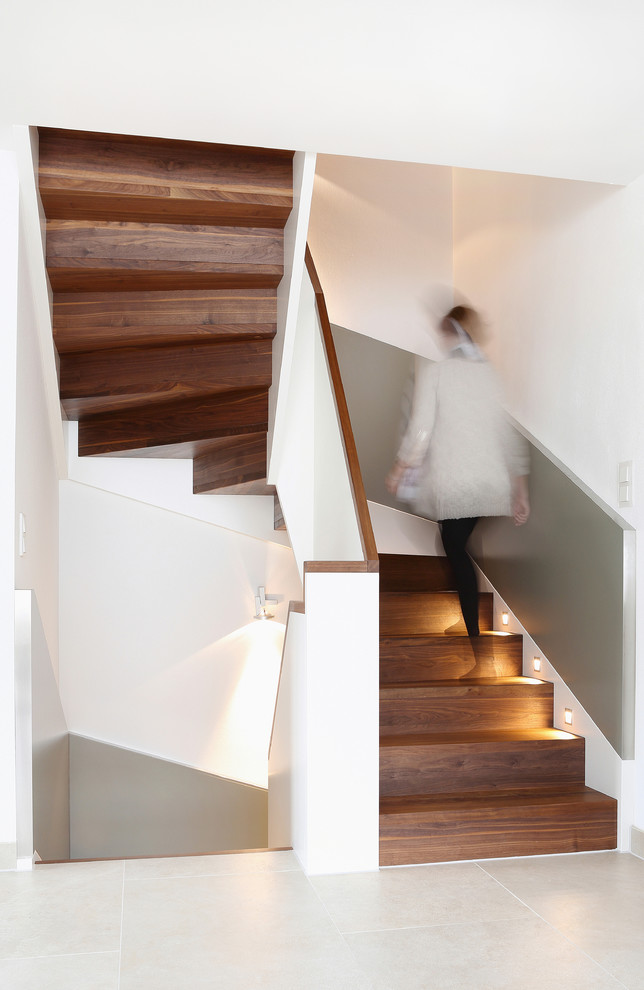 This is an example of a mid-sized contemporary wood u-shaped staircase in Munich with wood risers.