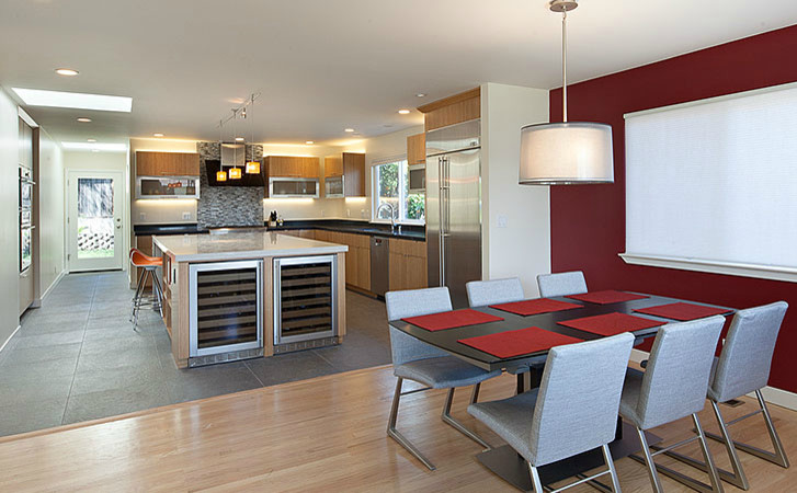 Inspiration for a large modern l-shaped cement tile floor and gray floor eat-in kitchen remodel with a drop-in sink, light wood cabinets, stainless steel appliances, an island, flat-panel cabinets, black backsplash, quartz countertops and ceramic backsplash