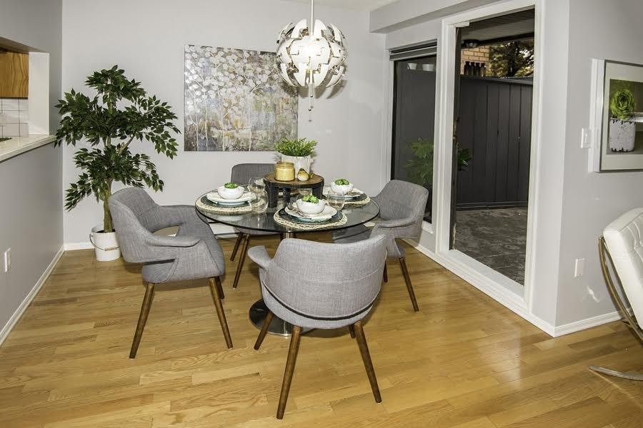 Small transitional open plan dining in Vancouver with grey walls and light hardwood floors.
