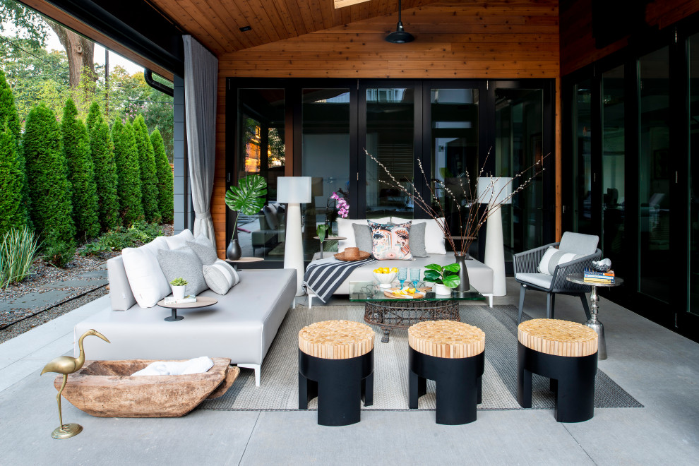 Inspiration for a small contemporary patio in Raleigh with concrete slab and a roof extension.
