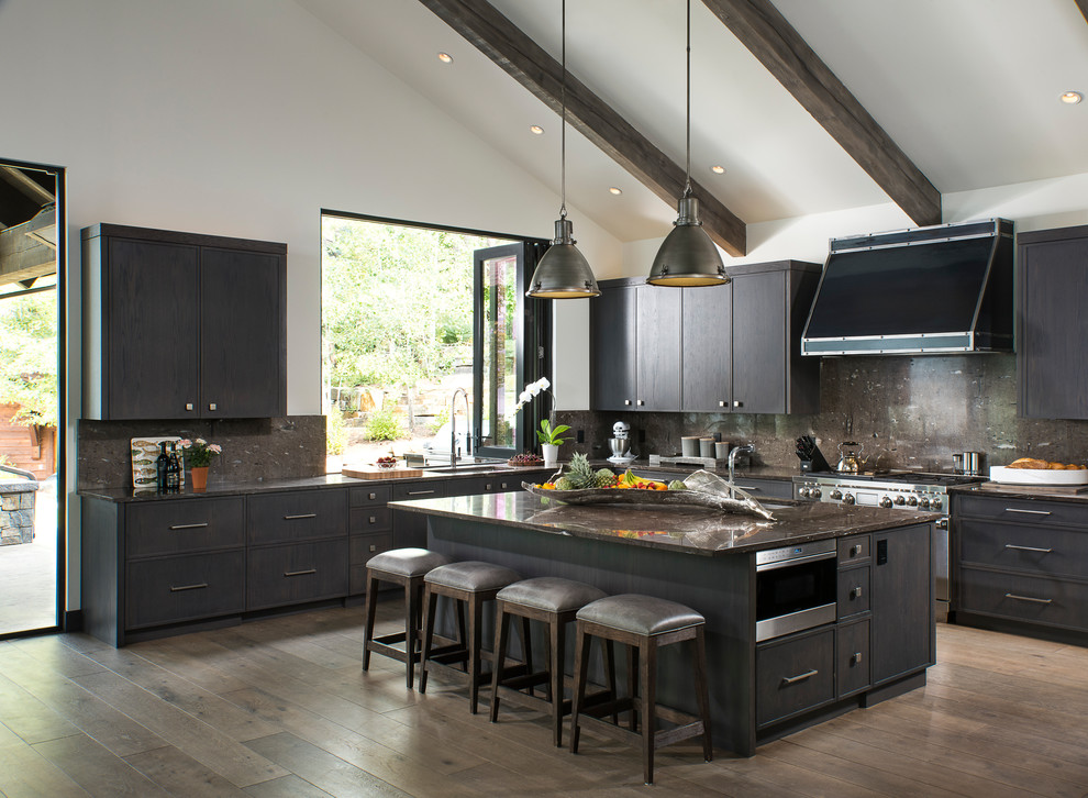 Photo of a country l-shaped kitchen in Other with a single-bowl sink, dark wood cabinets, brown splashback, stainless steel appliances and with island.