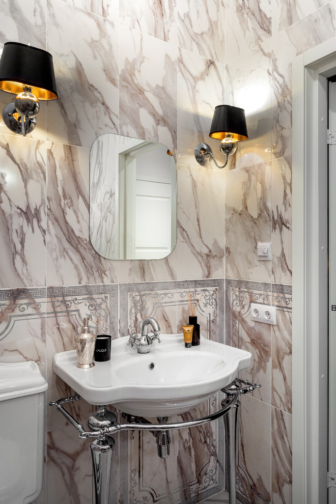 This is an example of a transitional powder room in Moscow with beige tile, a console sink, a two-piece toilet, marble and multi-coloured walls.