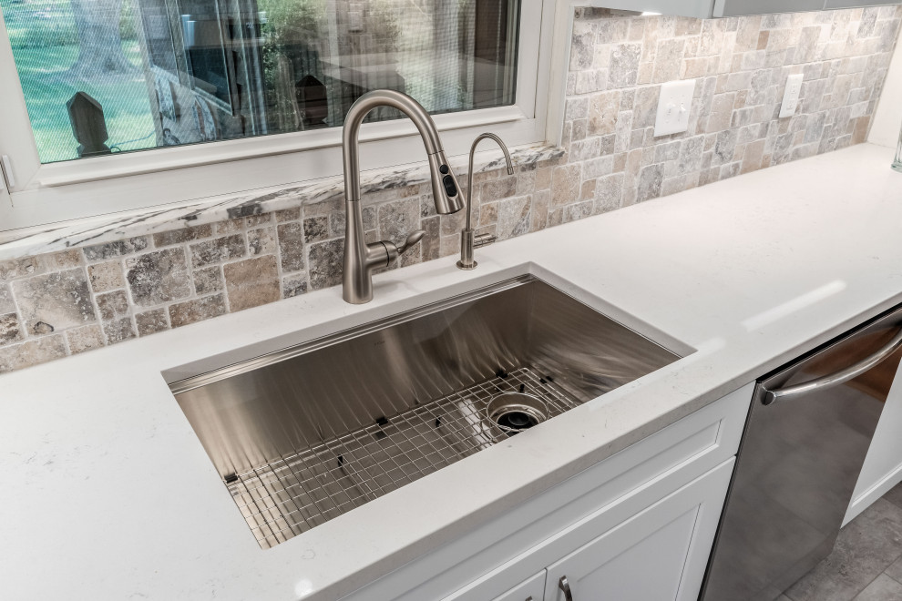 Example of a mid-sized transitional galley enclosed kitchen design in Columbus with shaker cabinets, white cabinets, quartz countertops, stone tile backsplash and white countertops